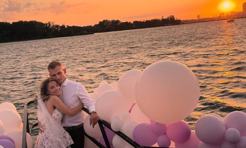 Couple with balloons at sunset
